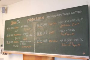 Programm des Festes auf deutsch und arabisch auf der Tafel im Hörsaal